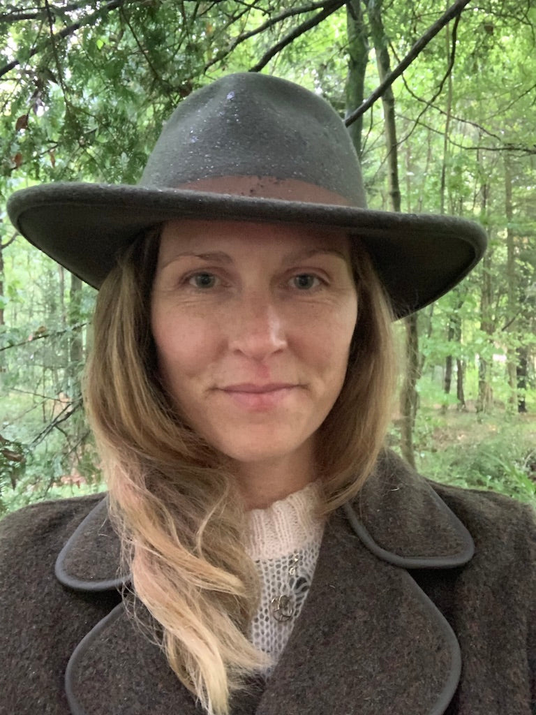 Ruth Rands, founder and CEO of Herd Wool and Wear in a felt hat in a forest
